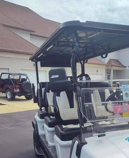Couple riding golf cart Miramar Beach